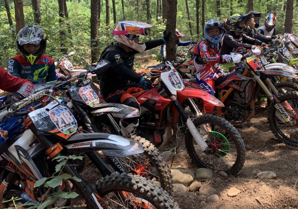 Eine Gruppe von Fahrern fährt mit einem leichten Dirtbike durch den Wald