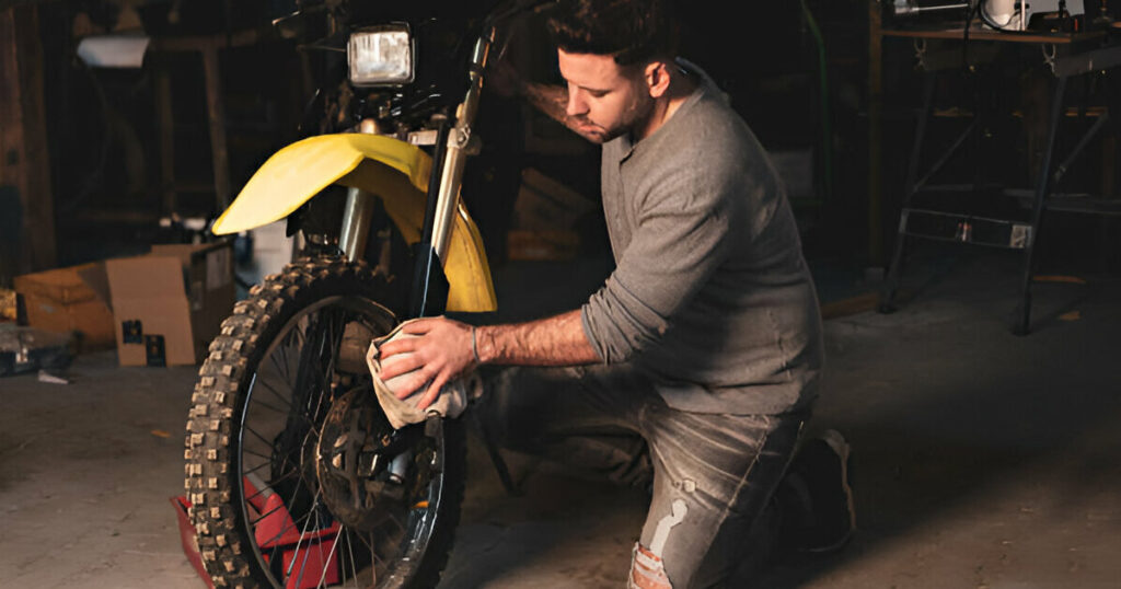 A man is cleaning a new dirt bike