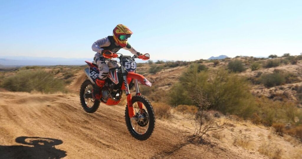 A person riding a dirt bike in the wild